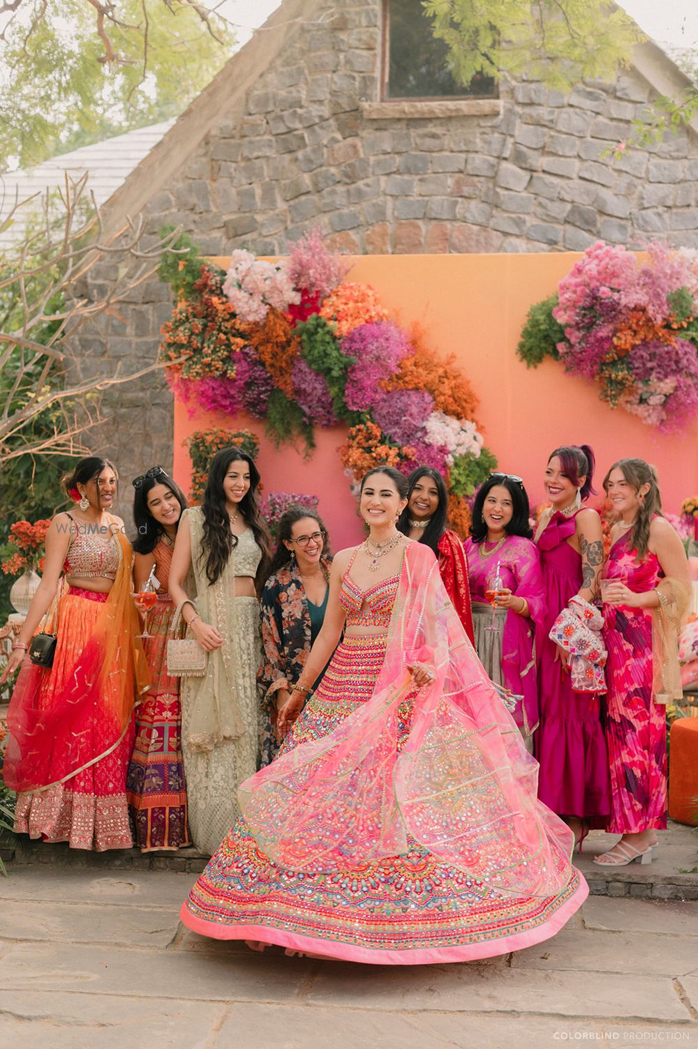 Photo of Lovely colourful mehendi shot with the bride twirling in her lehenga with bridesmaids