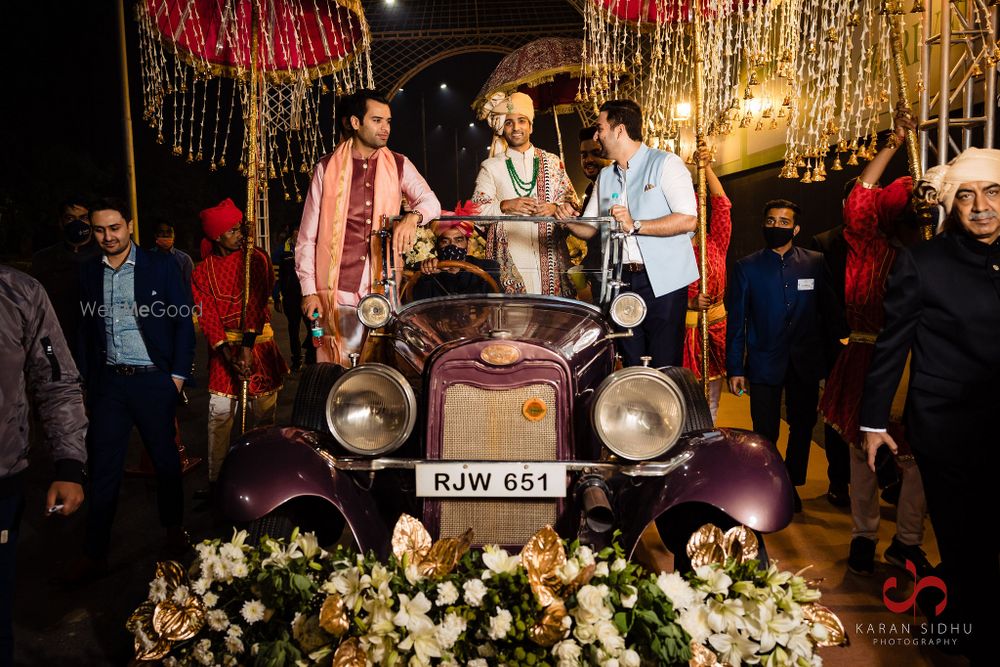 Photo of Groom entering in a vintage car.