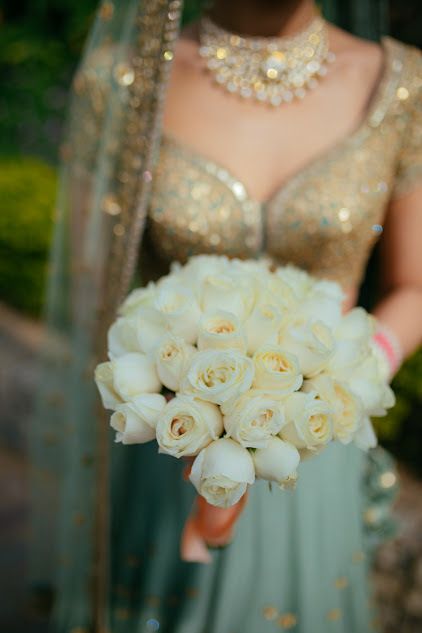 Photo of Bride in lehenga holding bouquet