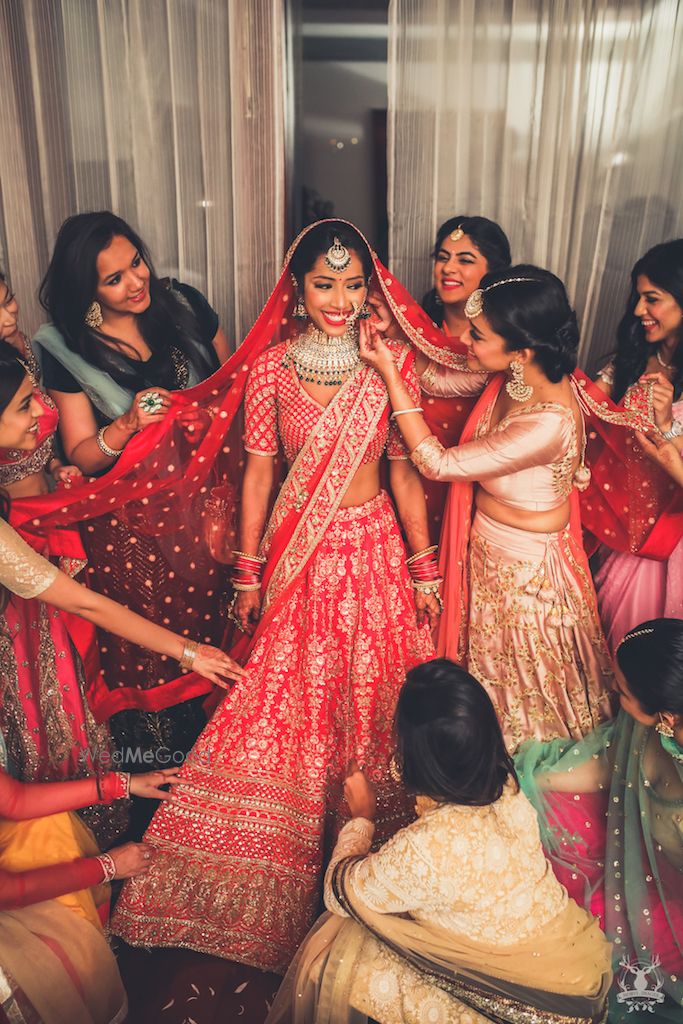 Photo of Bridal getting ready shot with bridesmaids pulling cheeks