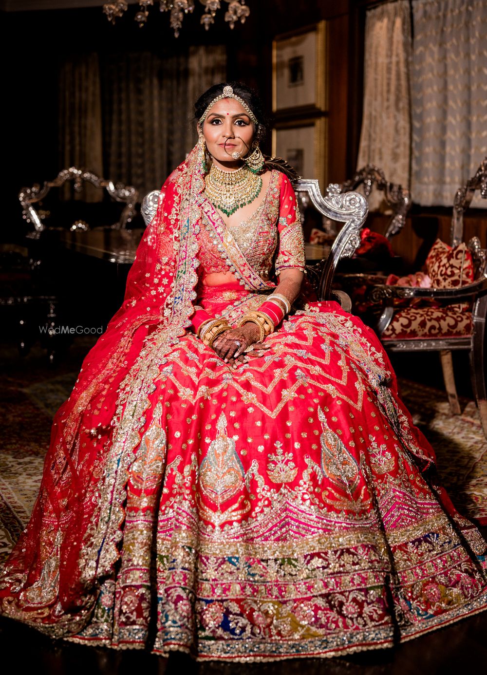 Photo of A bridal portrait captured with the bride in a bright pink and red ombre lehenga