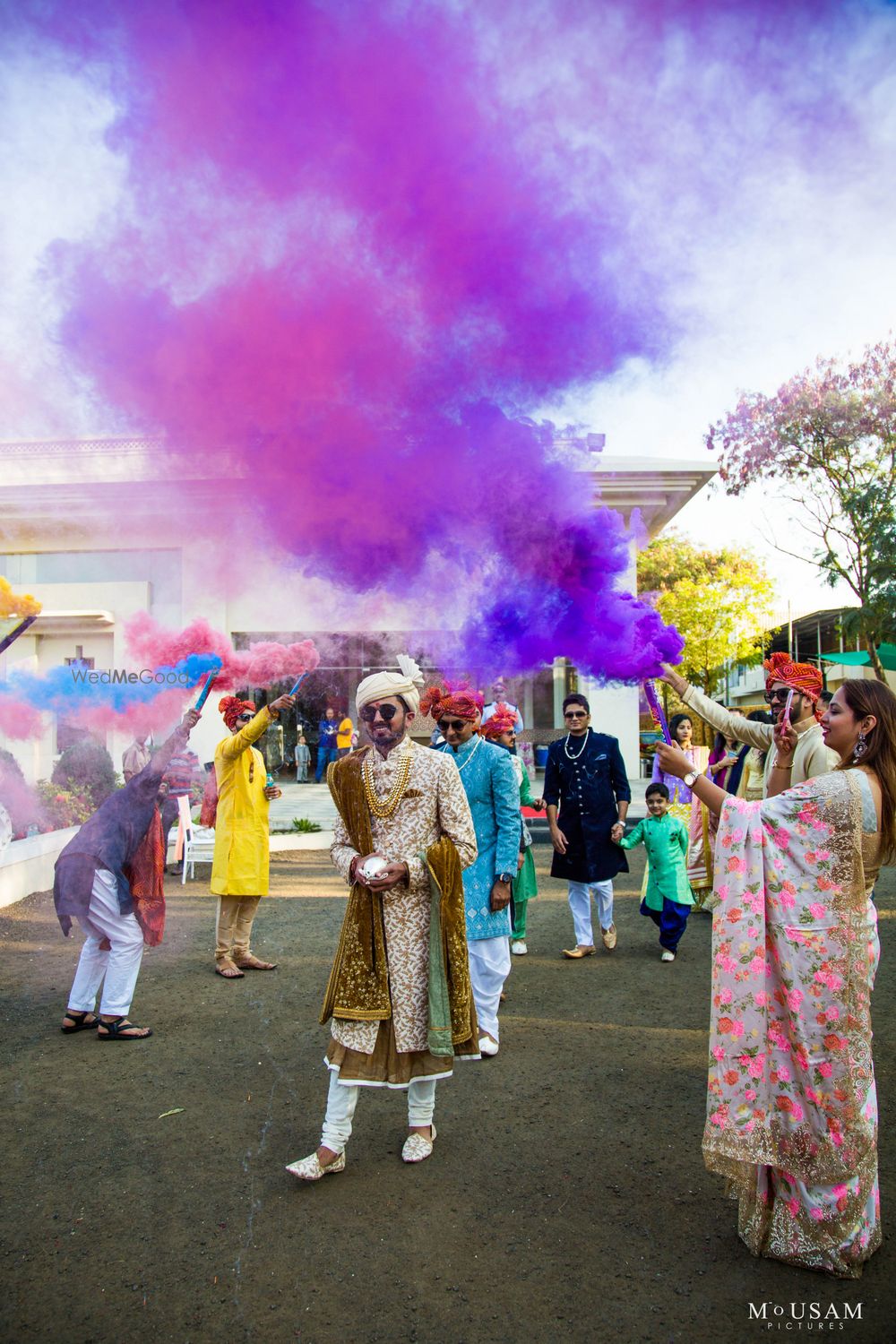 Photo of guests holding smoke sticks for groom entry