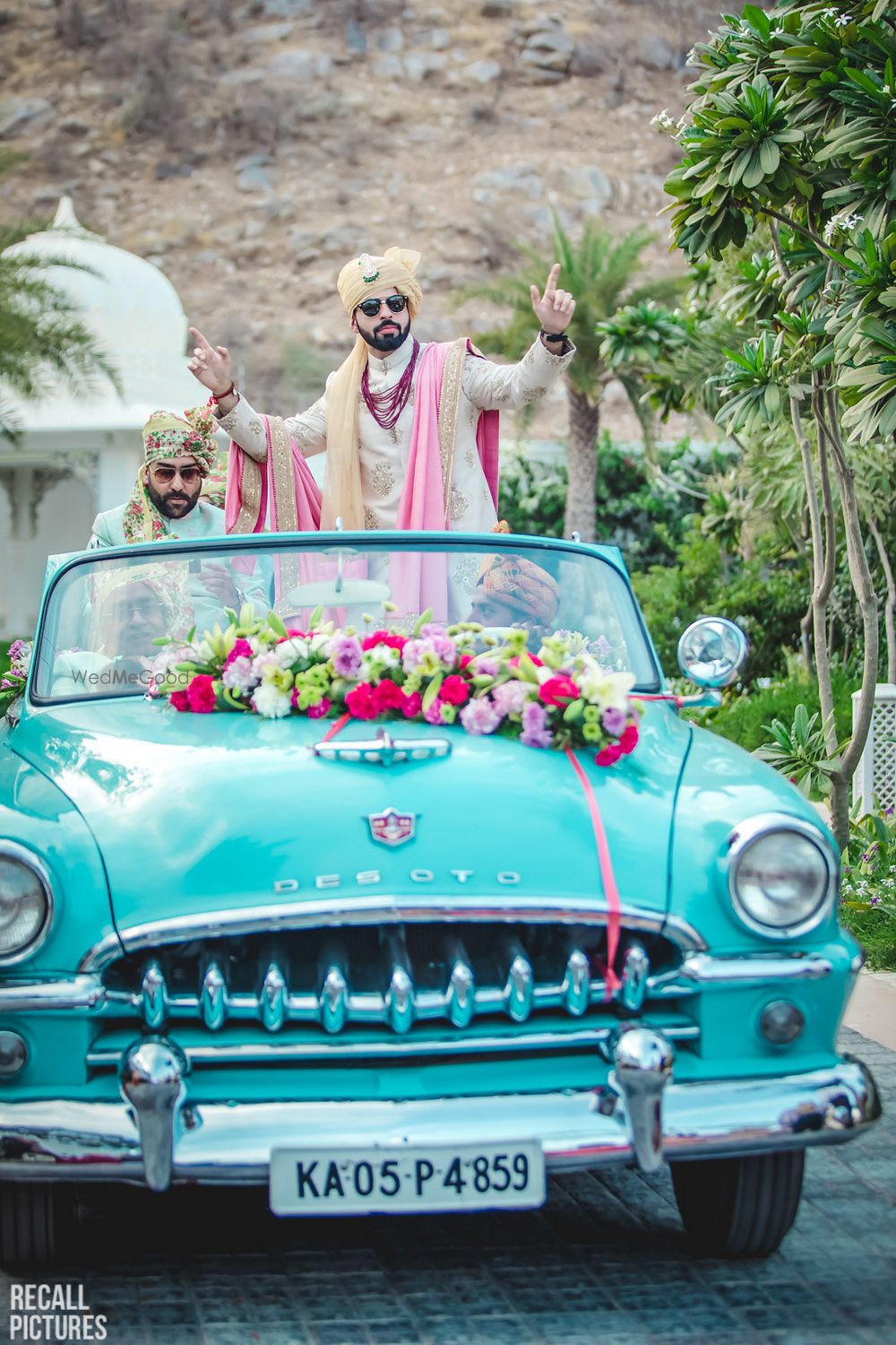 Photo of Groom dancing and entering in a vintage car