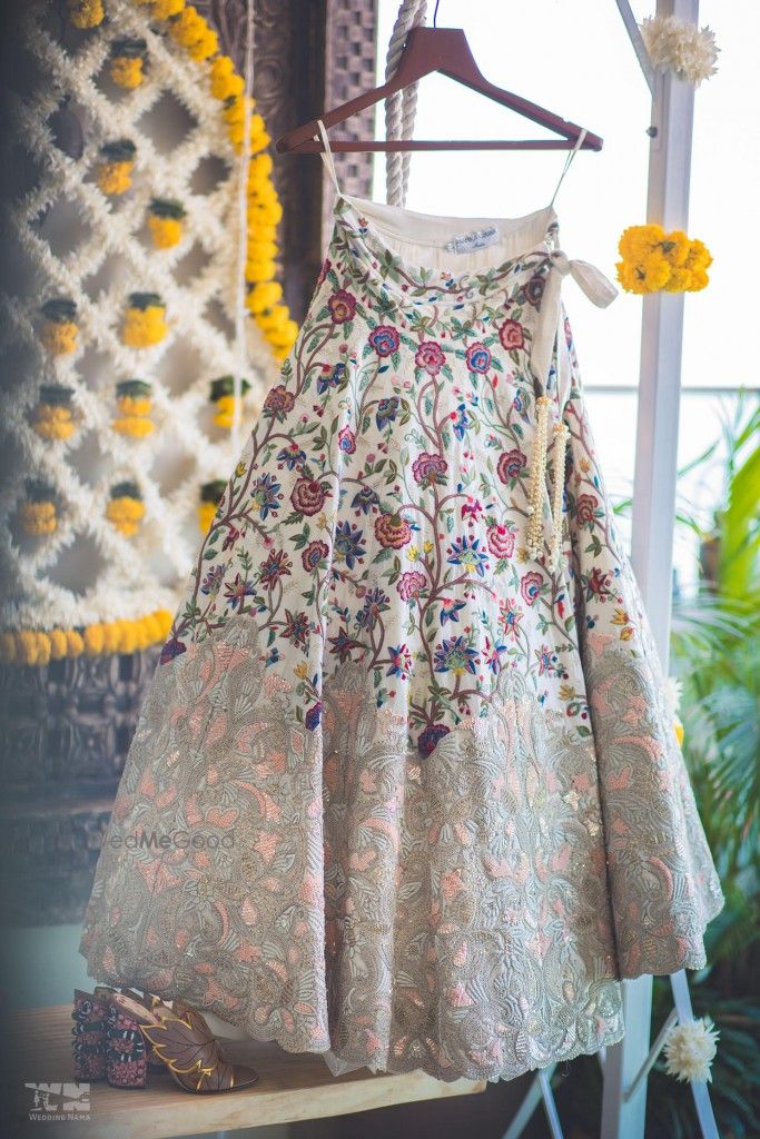 Photo of White and peach lehenga on hanger