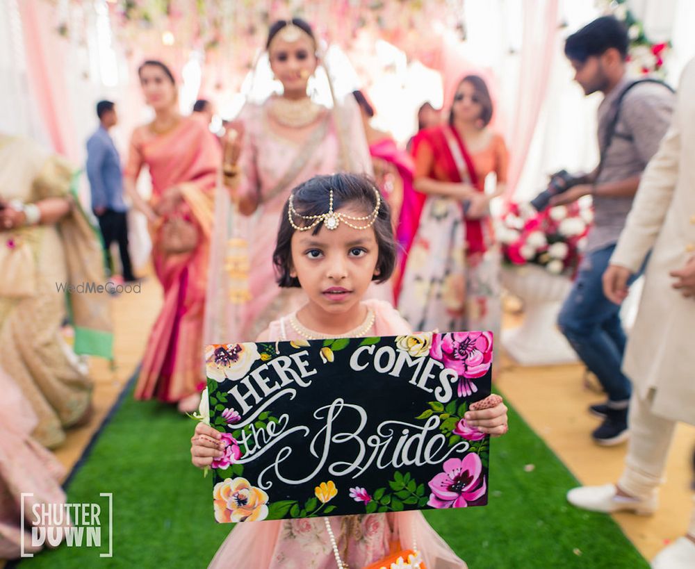 Photo of Cute bridal entry with niece holding board