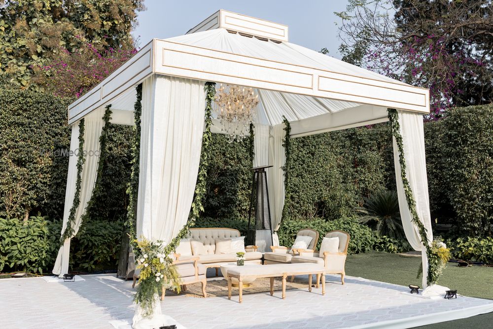 Photo of All white minimalistic outdoor wedding mandap with foliage decor