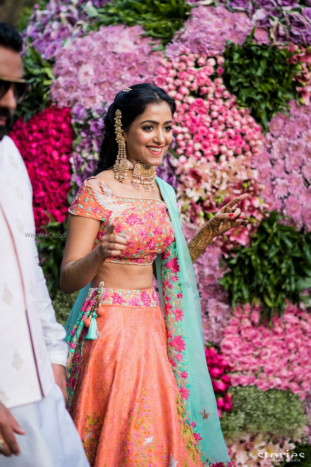 Photo of Mehendi bridal look in peach lehenga with unique earrings