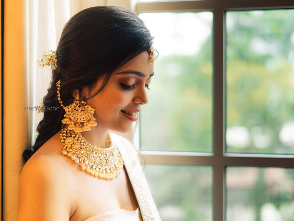 Photo of A bride flaunting her gold choker and waterfall earrings with multiple jhumkis