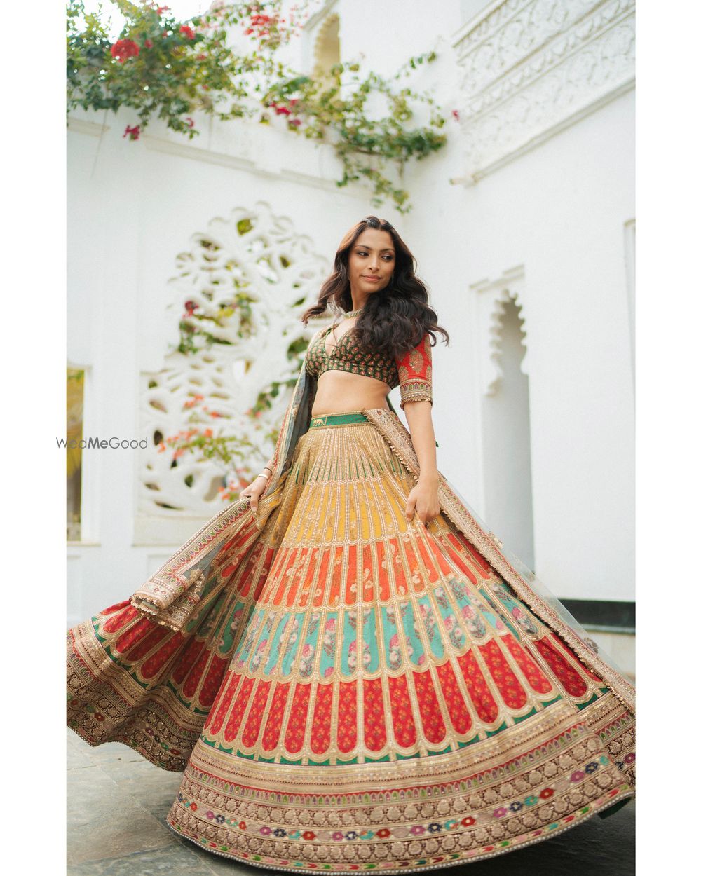 Photo of Gorgeous multi coloured lehenga with the bride twirling in it on her mehendi day