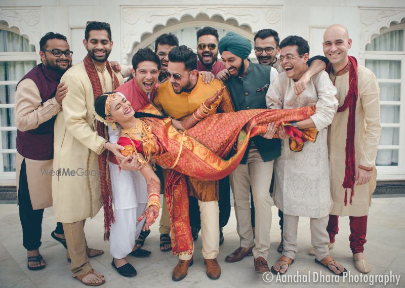 Photo of Fun bridal portrait with groomsmen picking bride up