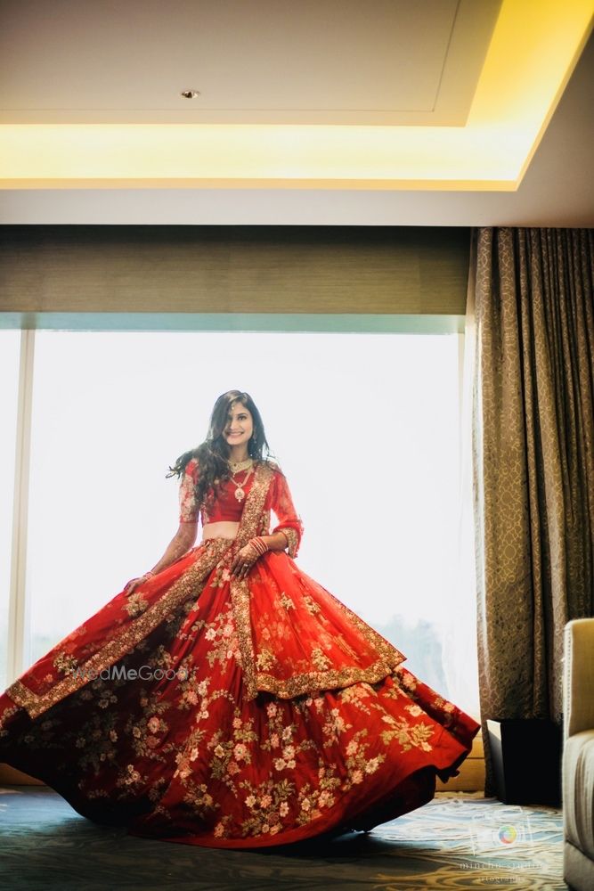 Photo of Bride twirling in red Shyamal bhumika lehenga