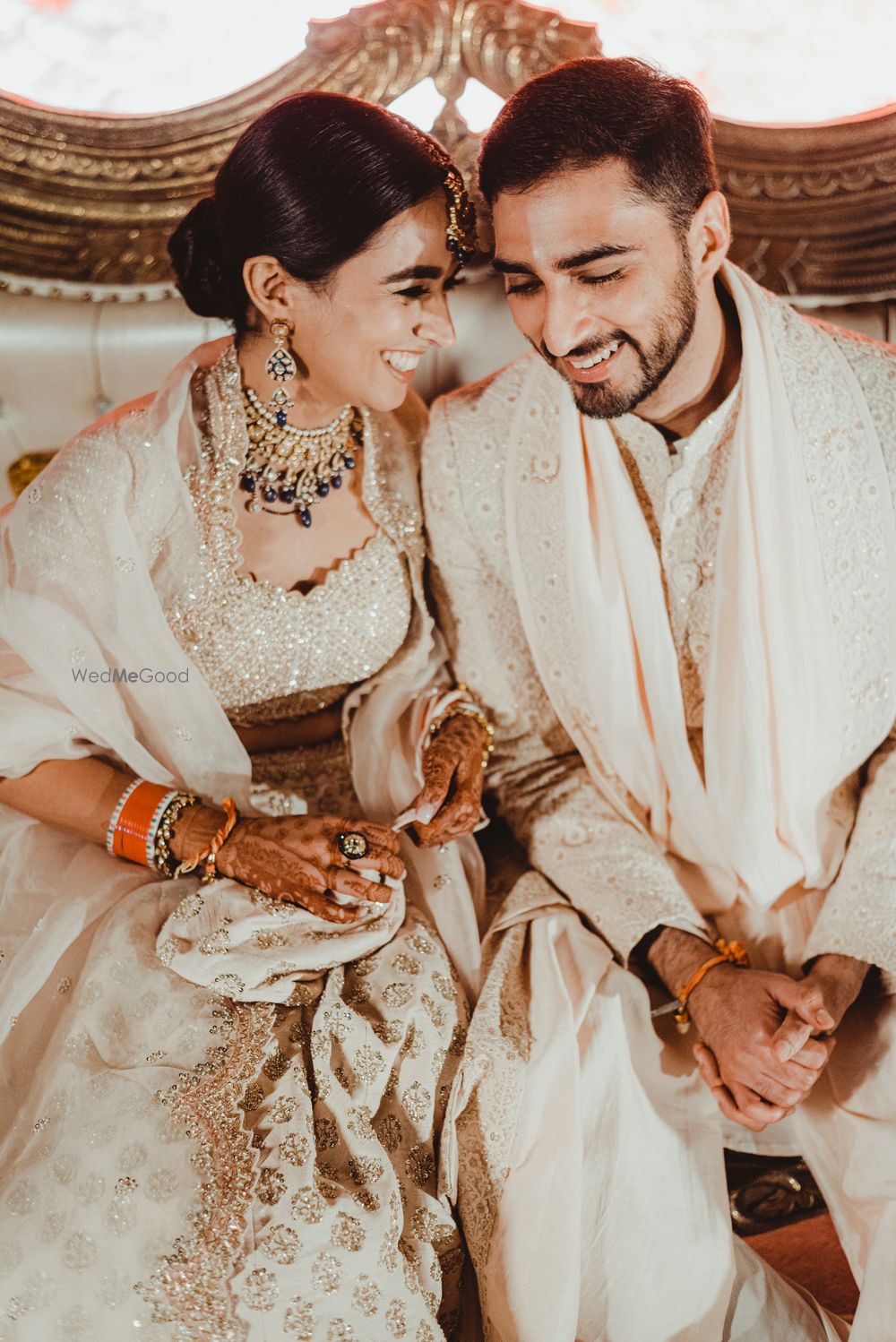 Photo of cute couple shot with the bride whispering to the groom