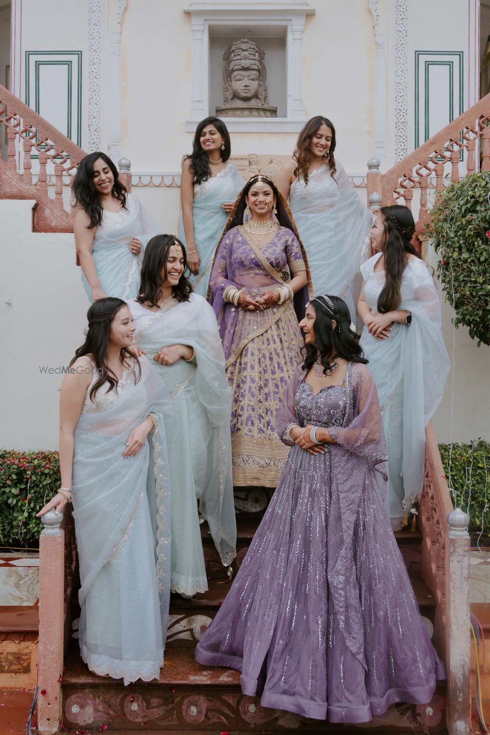 Photo of Lovely shot of co-ordinated bridesmaids in pastel sarees and the bride in a lovely lilac lehenga on the wedding day