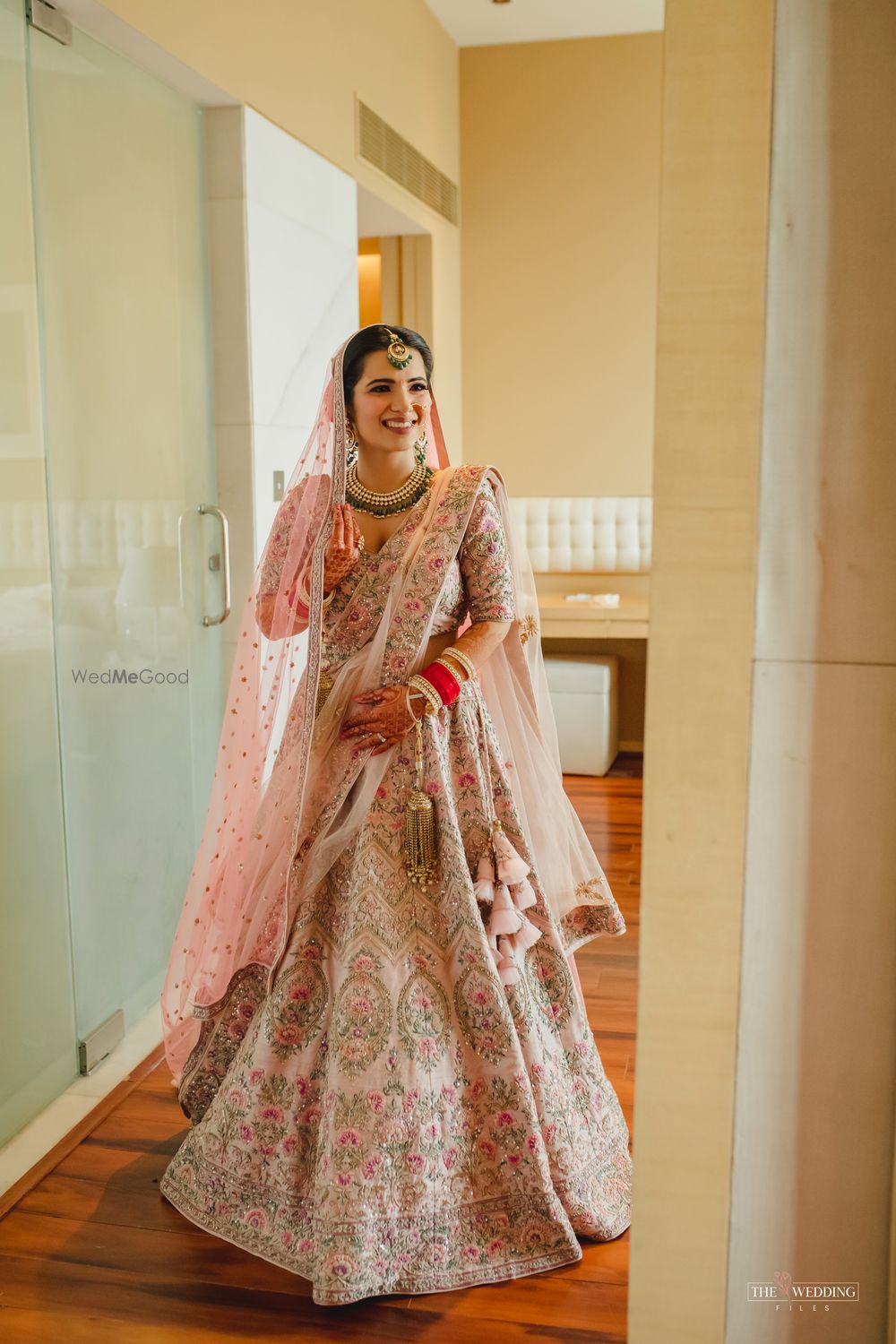 Photo of Bride dressed in a baby pink lehenga