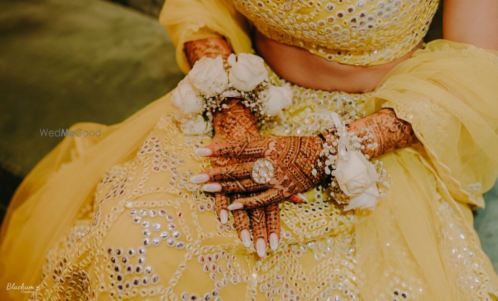 Photo of pretty mehendi hand photo idea with flower bracelet