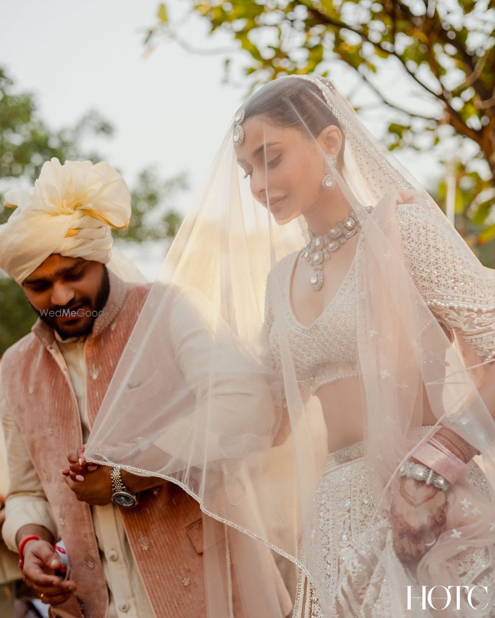 Photo of Stunning bridal shot of a bride holding her all white veil