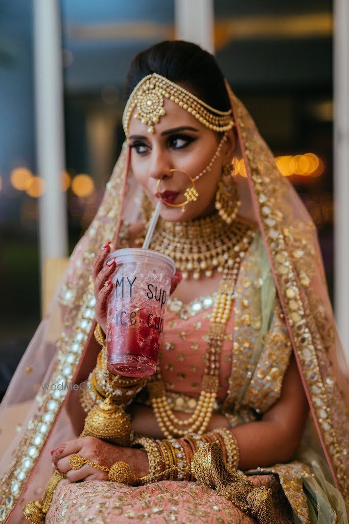 Photo of Bride getting ready shot sipping from sipper