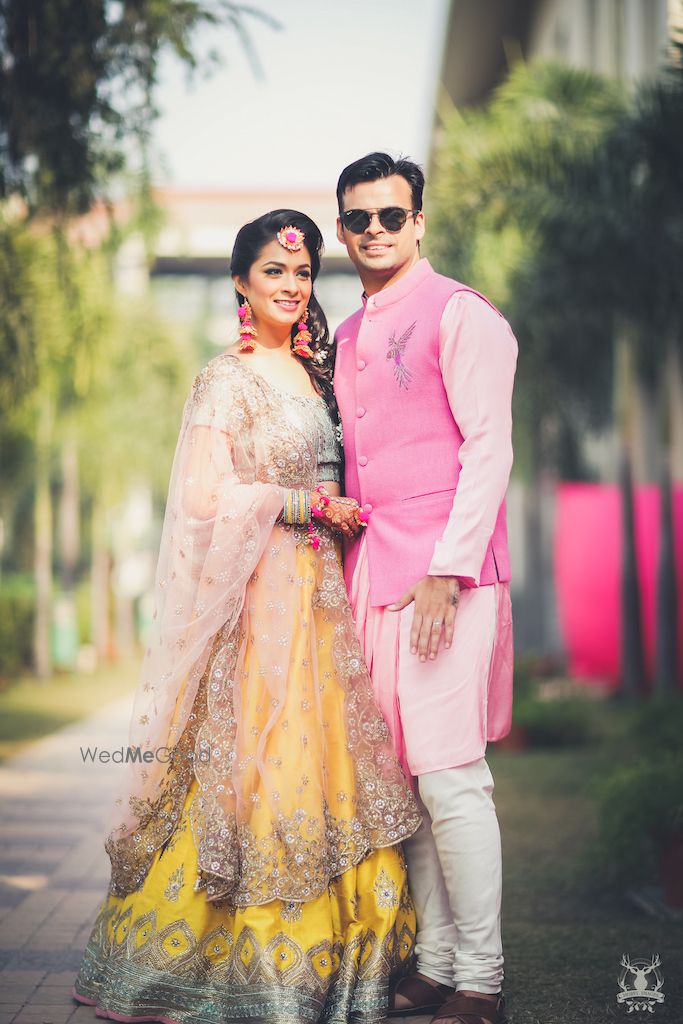 Photo of Bride and groom posing contrasting on mehendi