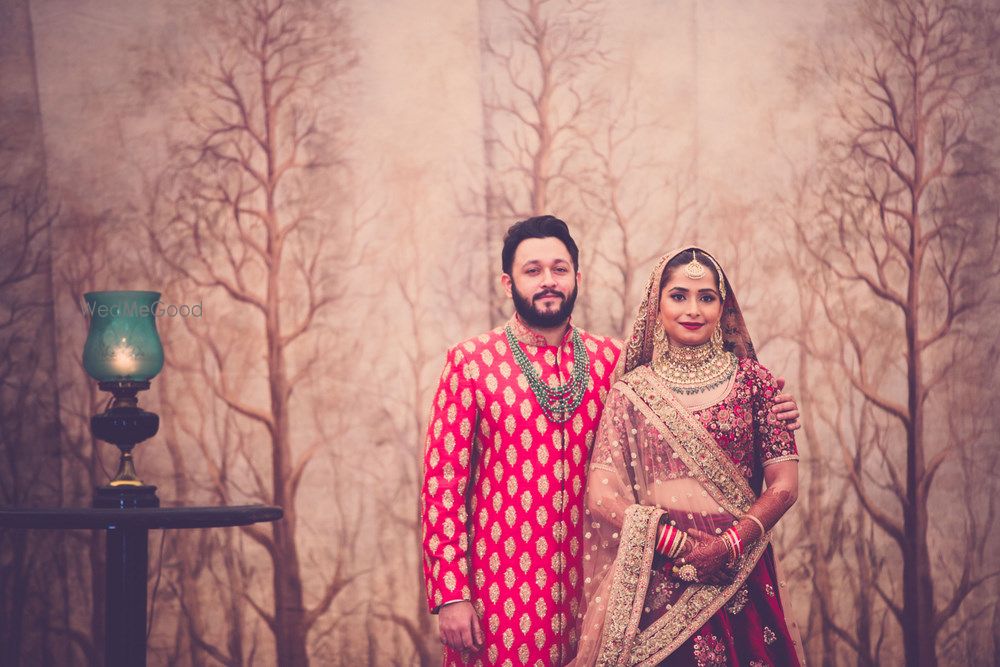 Photo of Red and maroon bride and groom