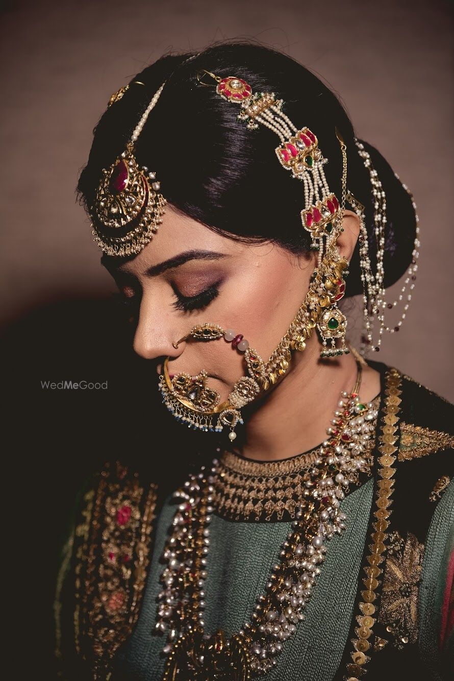 Photo of A bride with heavy jewelry, mangtikka an nath. d