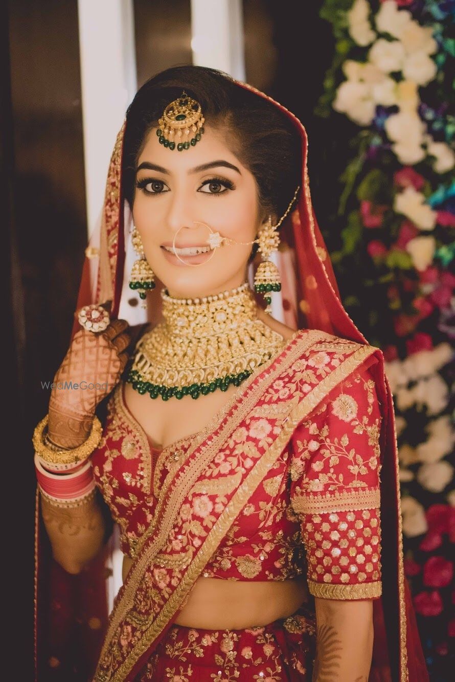 Photo of Bride in red with green contrasting jewellery