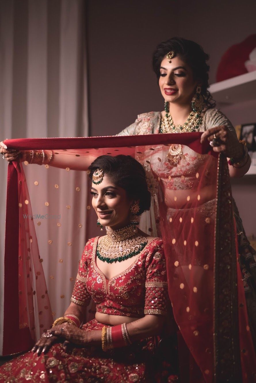 Photo of Bride with sister getting ready shot idea