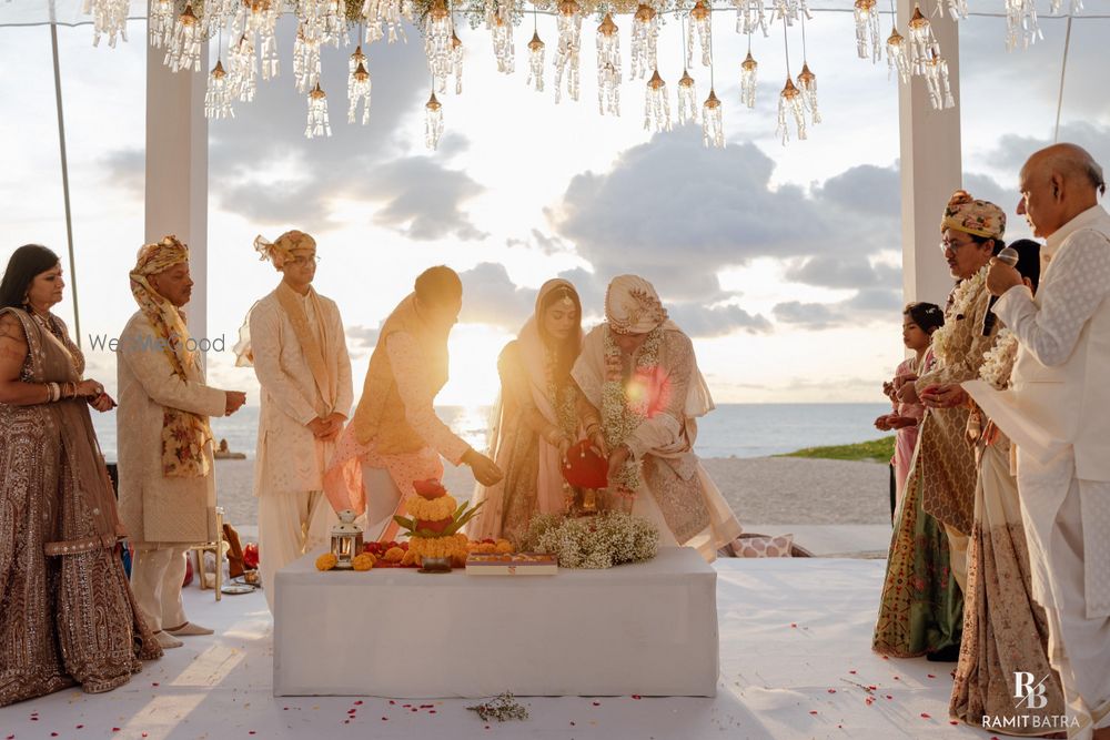 Photo of Lovely sunset beach wedding shot as the couple takes pheras