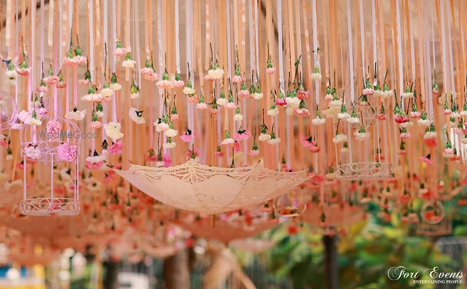 Photo of Beautiful peach decor with suspended umbrella and bird cage for mehendi