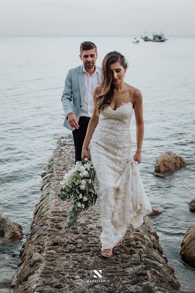 Photo of Bride wearing white wedding gown by the beachside