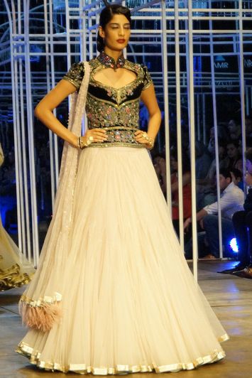 Photo of powder pink net flared lehenga with blue velvet corset blouse