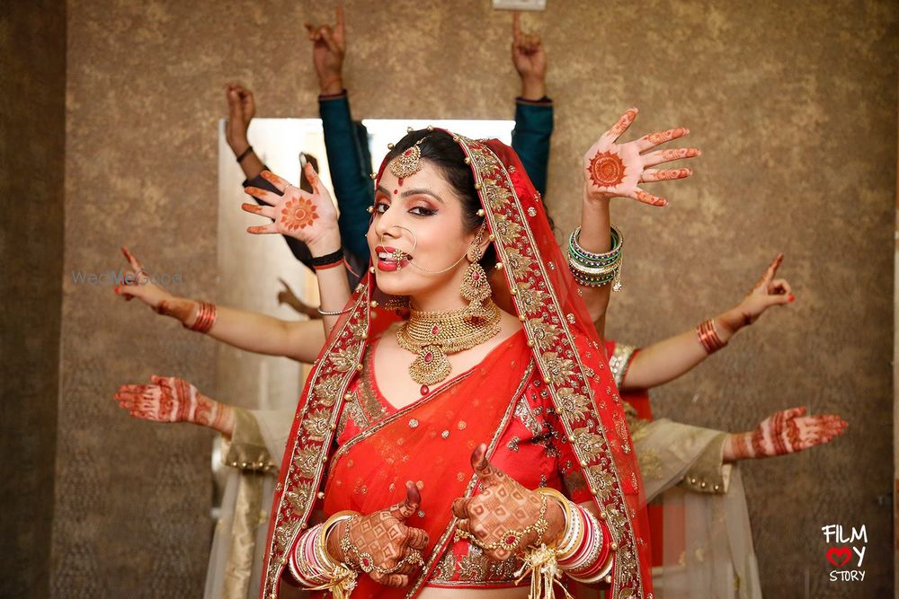 Photo of Bride in red with bridesmaids showing hands