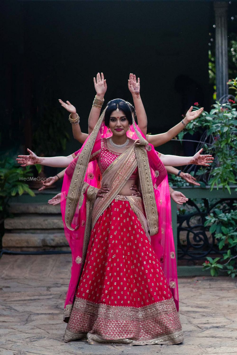 Photo of Hot Pink Bridal Lehenga with Bridesmaids Hands