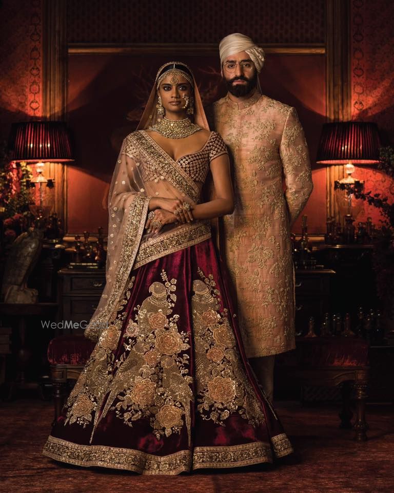 Photo of Maroon bridal lehenga and peach sherwanu sabyasachi