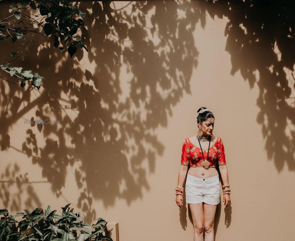 Photo of bride wearing her blouse and shorts before getting ready