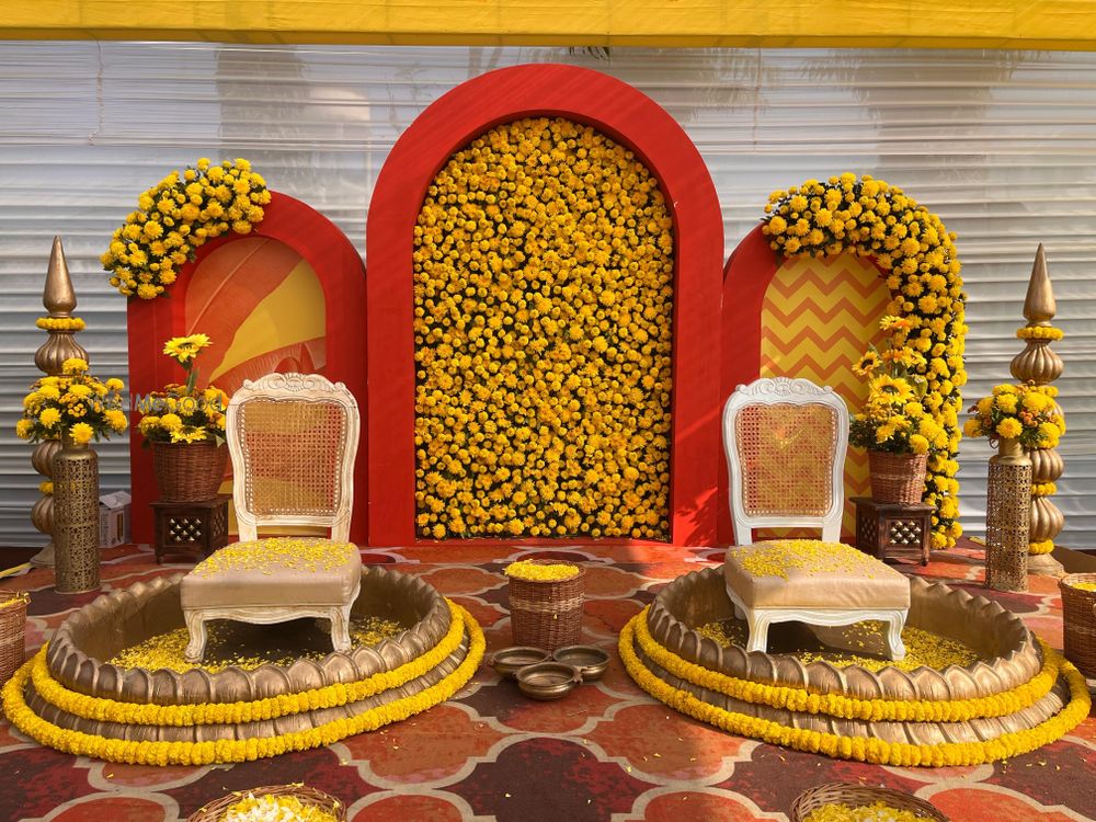 Photo of Stunning gendaphool wall in orange combination for haldi ceremony decor