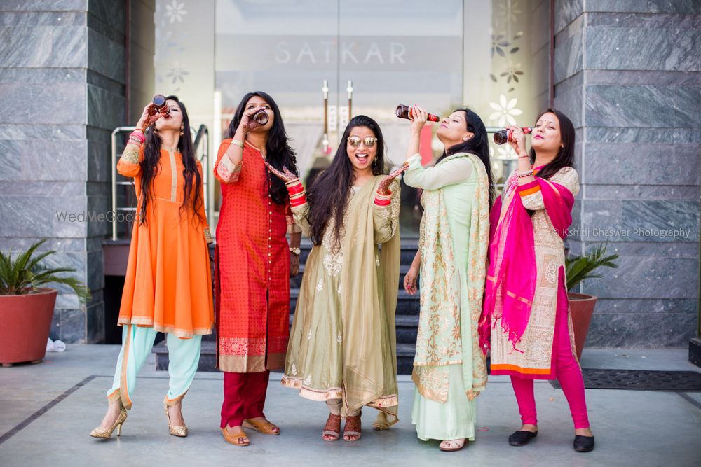 Photo of Bridesmaids drinking from bottles on mehendi