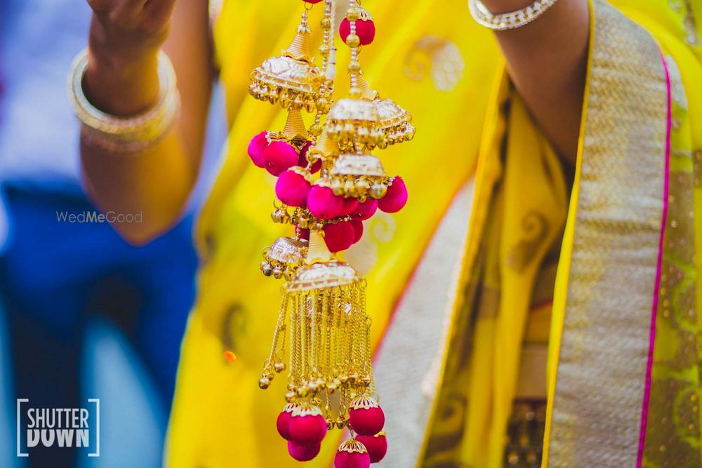 Photo of hanging gold and bright pink pom pom kaleere