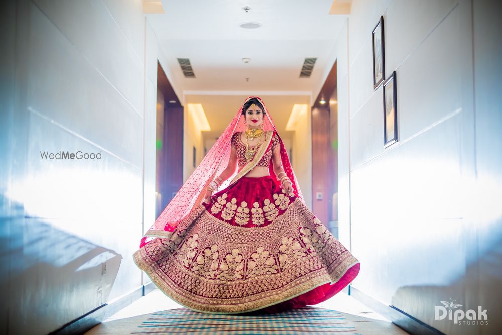 Photo of Twirling bride bridal portrait in red lehenga