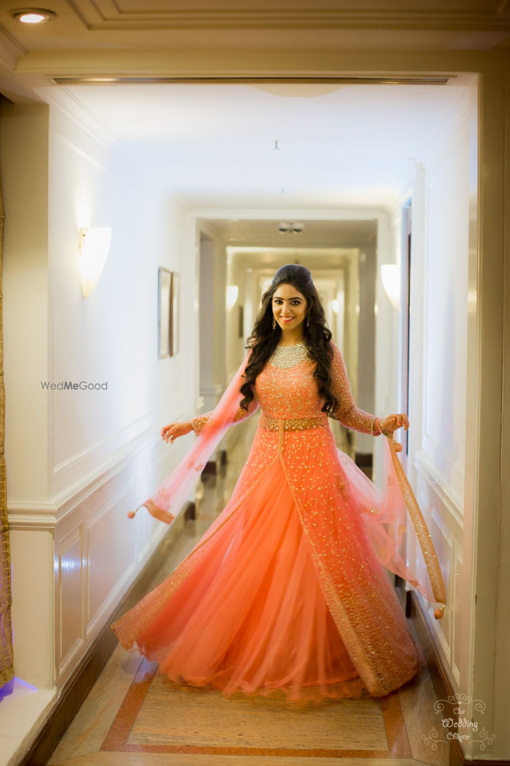 Photo of Bride twirling in peach engagement lehenga