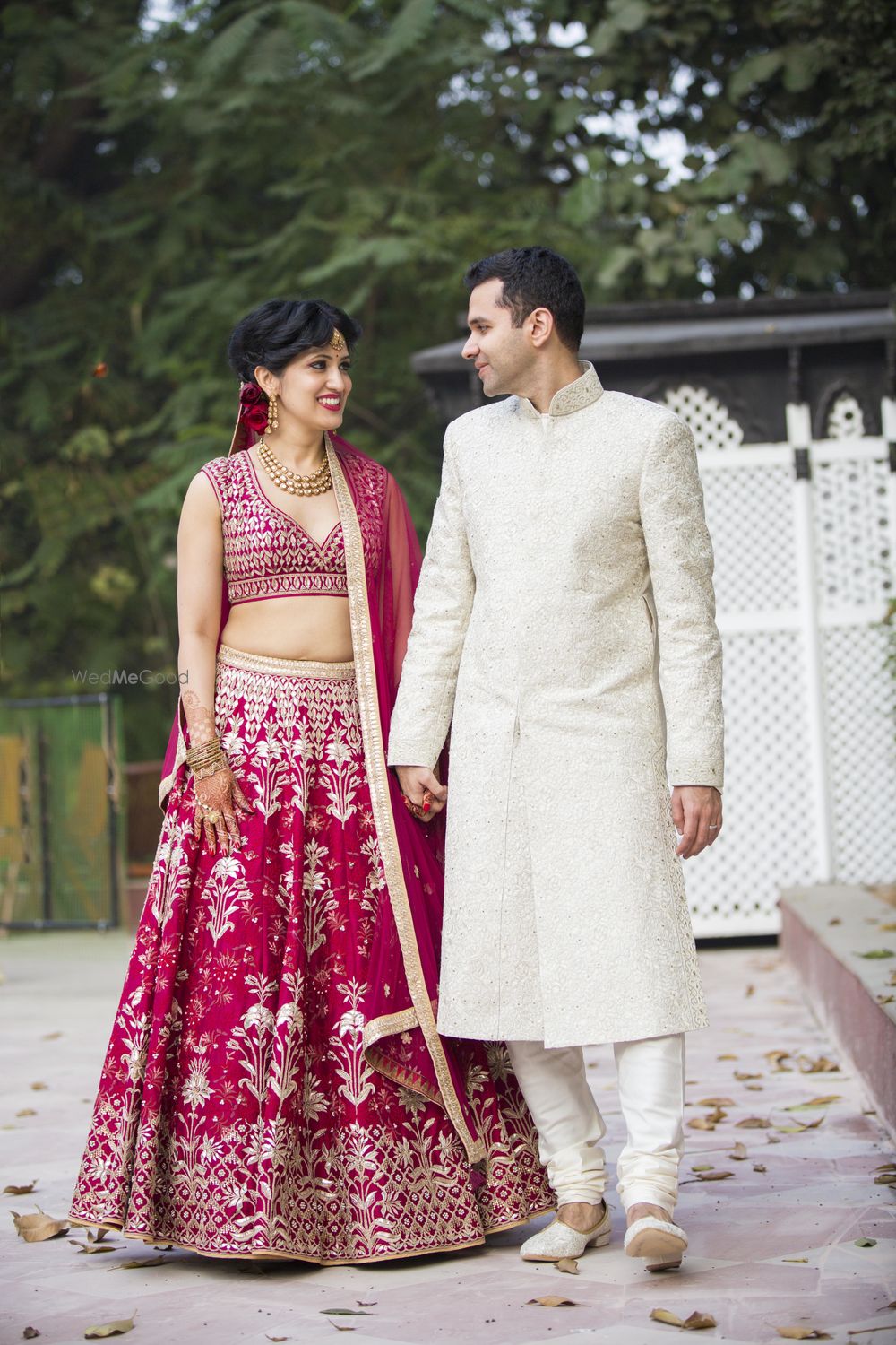 Photo of Matching bride and groom with bride in maroon and groom in white