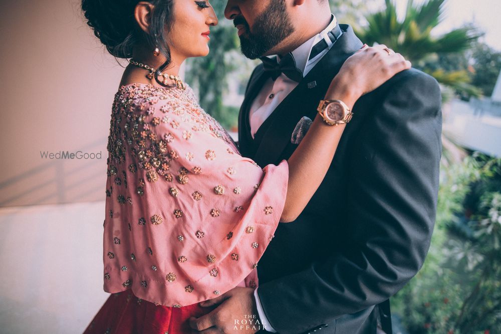 Photo of Embellished light pink cape with red lehenga