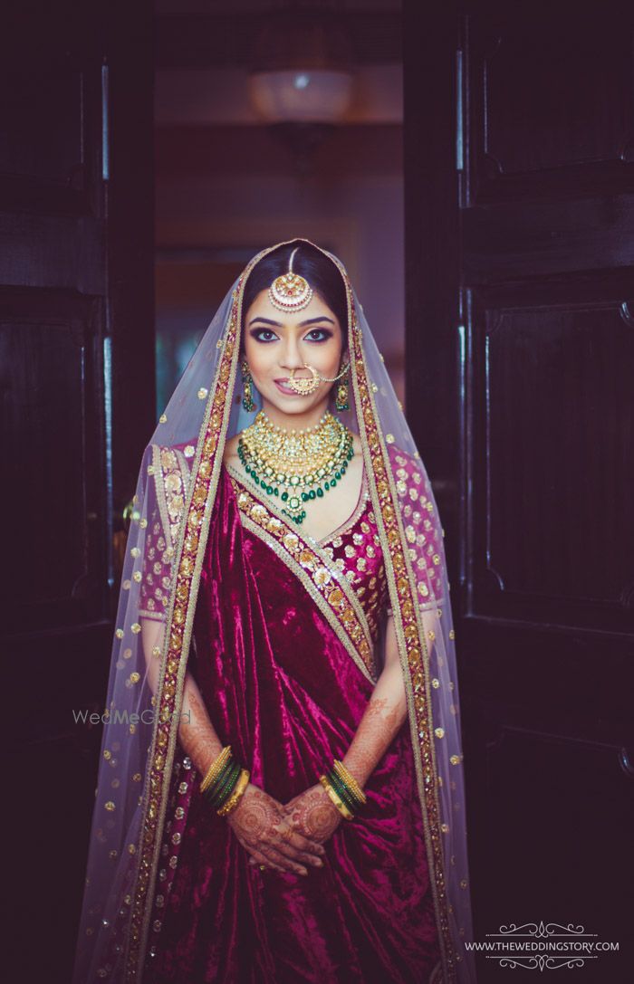 Photo of Maroon bridal lehenga with green contrasting jewellery