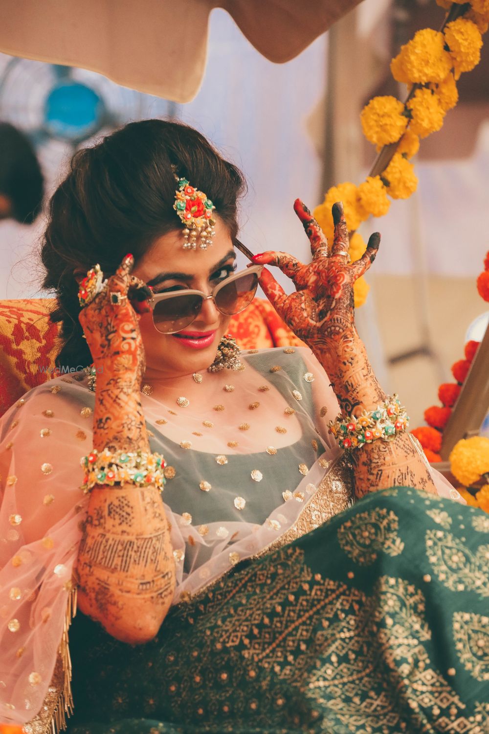 Photo of Bridal portrait on mehendi wearing sunglasses