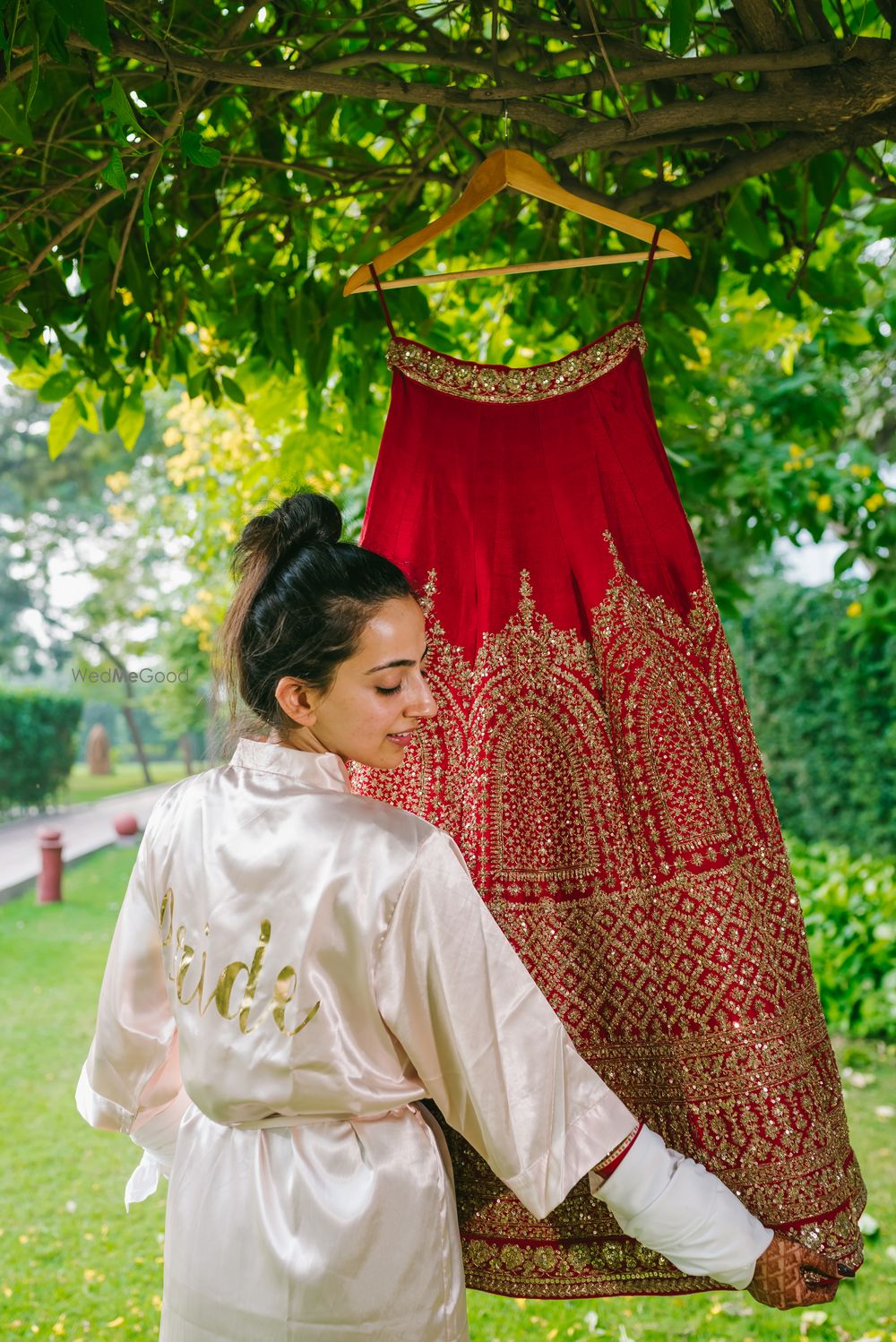 Photo of Bride in robe with lehenga on hanger