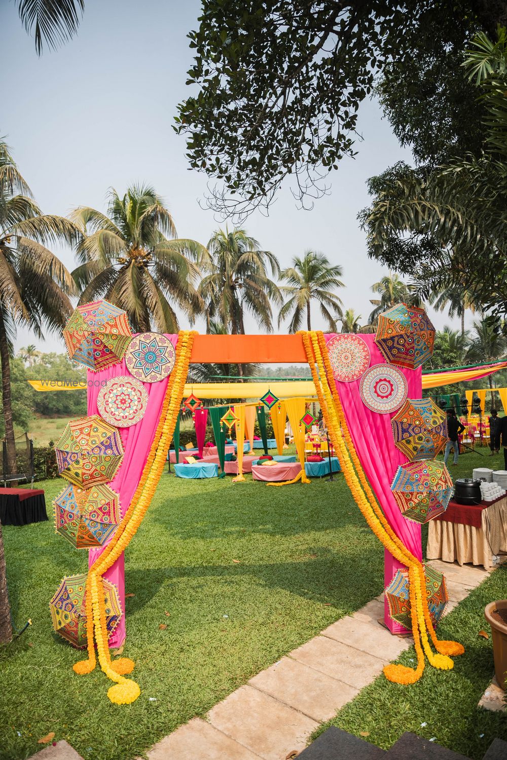 Photo of Colourful and funky mehendi entrance decor with multi-coloured umbrellas and drapes