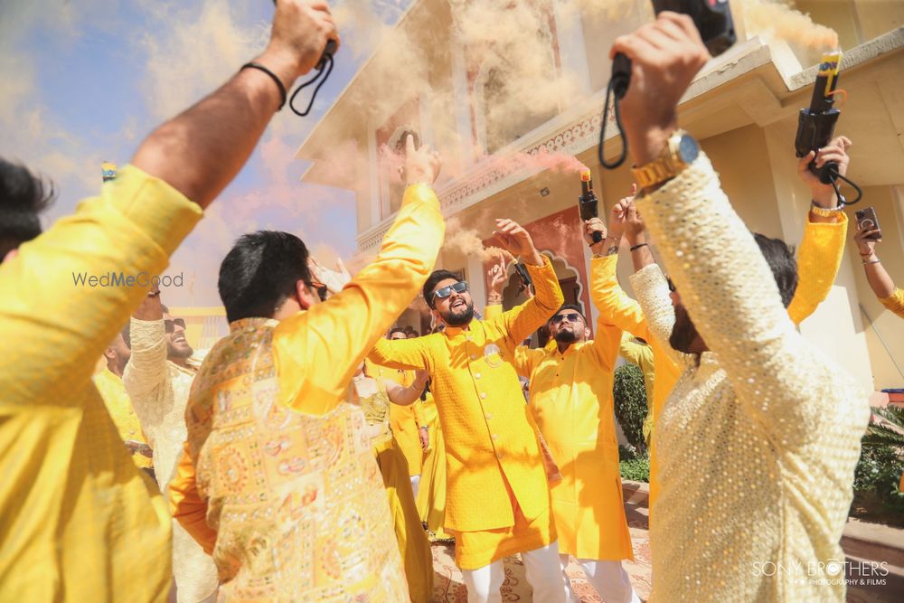 Photo of Fun groom entry for the haldi with groomsmen and smoke bombs