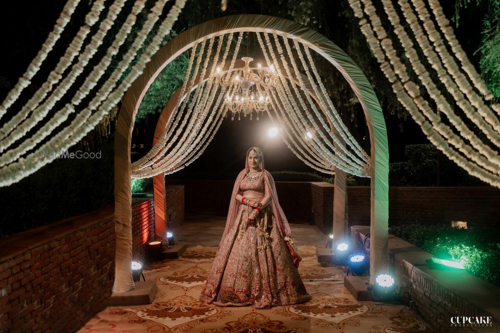 Photo of Bride standing against the wedding entrance