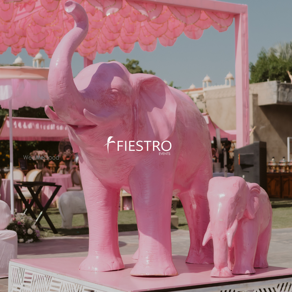 Photo of Statement pink elephant statues used in decor for an outdoor wedding