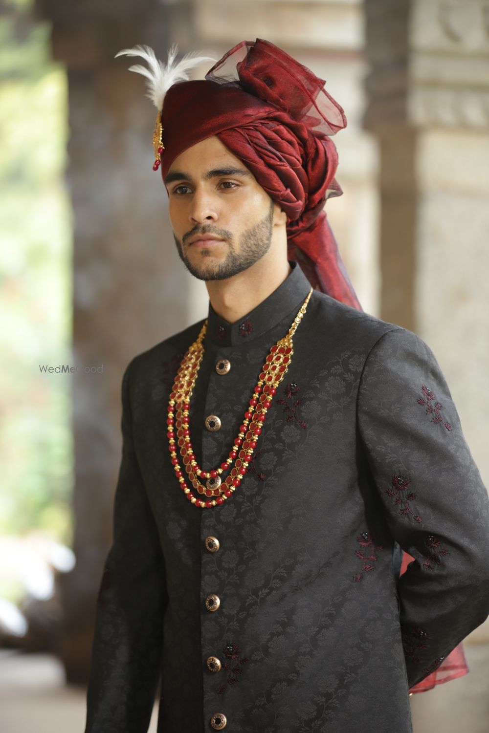 Photo of Groom in embroidered black sherwani and deep red safa.