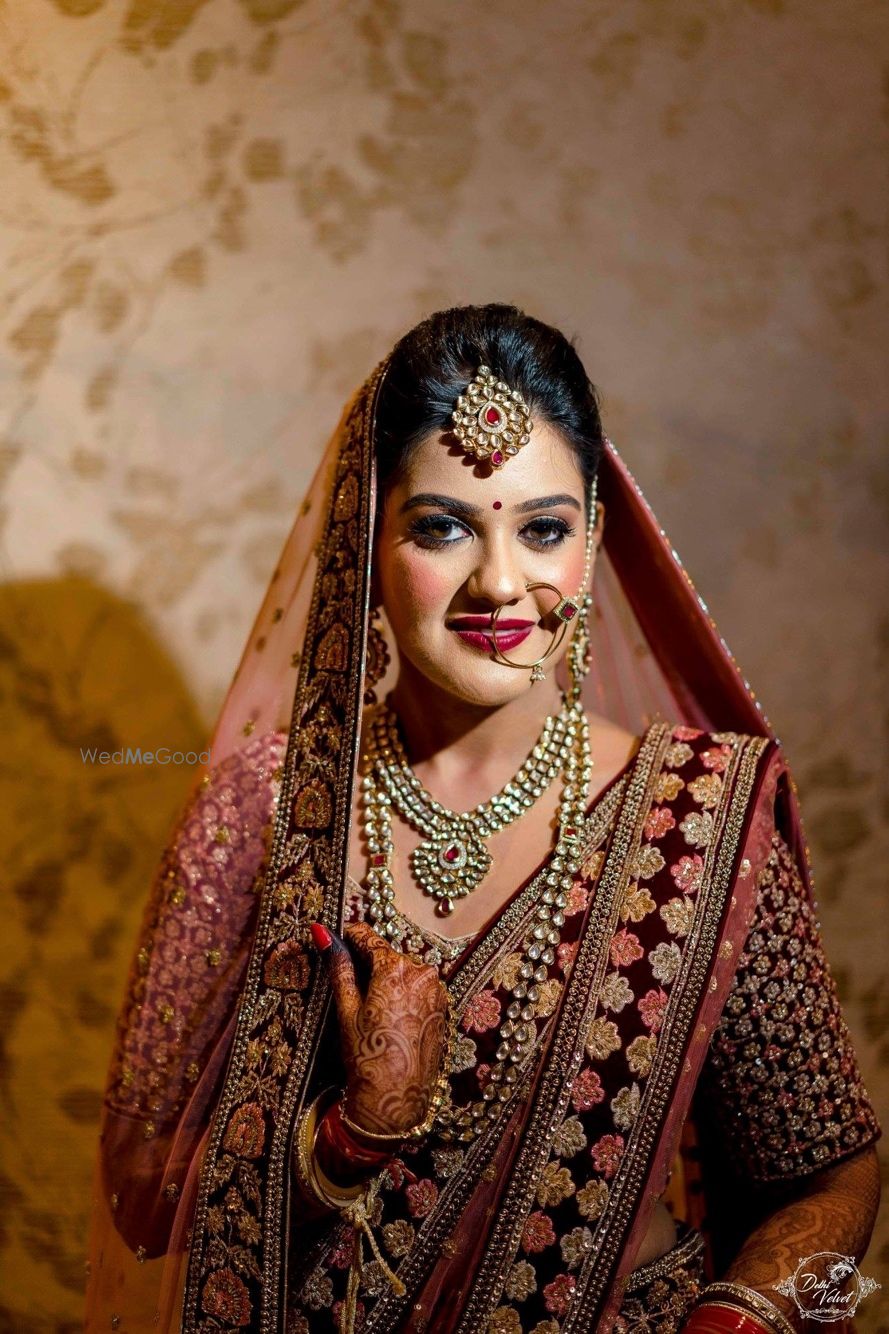 Photo of Bride with heavy blush in maroon winter lehenga